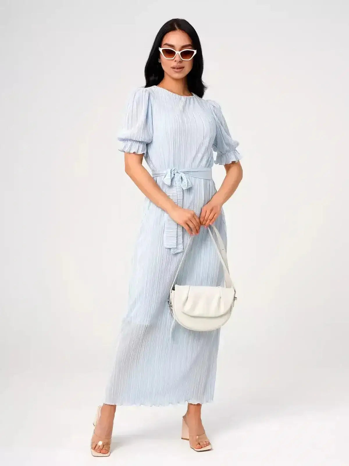 Model wearing the Angel Maxi Dress in light blue, featuring pleating and a waist tie, by Lauven.