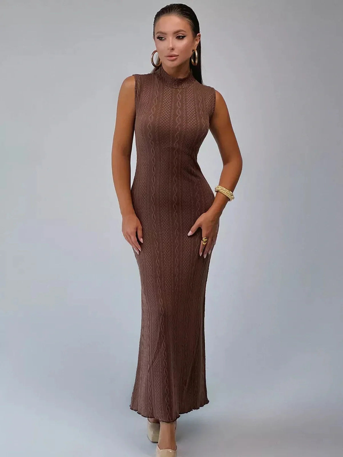 Stylish model showcasing the Aurora Maxi Dress by Lauven, a sleeveless fitted gown with jacquard cable texture.