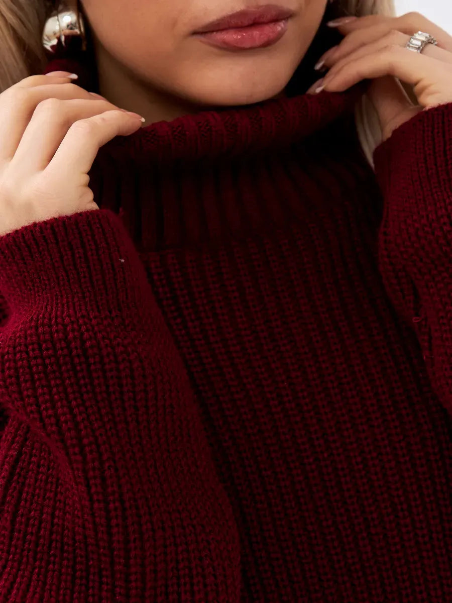 Close-up of a woman wearing the Crimson Pullover by Lauven, featuring a high neck and rich burgundy knit texture.