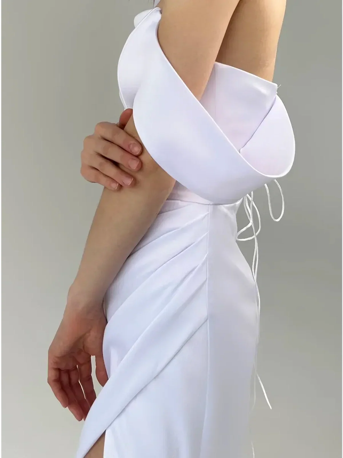 Eira Occasion Dress by Lauven featuring a white satin off-shoulder design with draping and a leg slit.