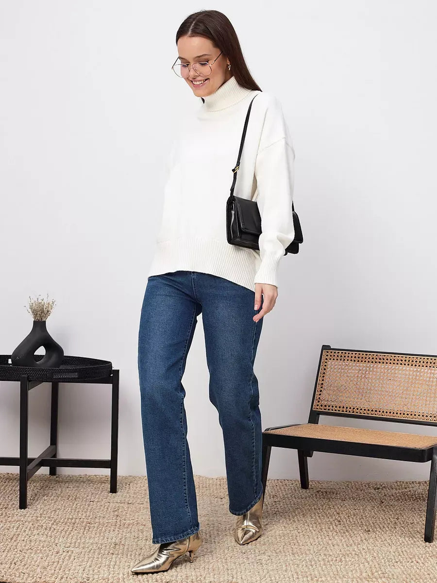 Woman wearing Elara Sweater in milk white with jeans and a black purse, styled by Lauven.