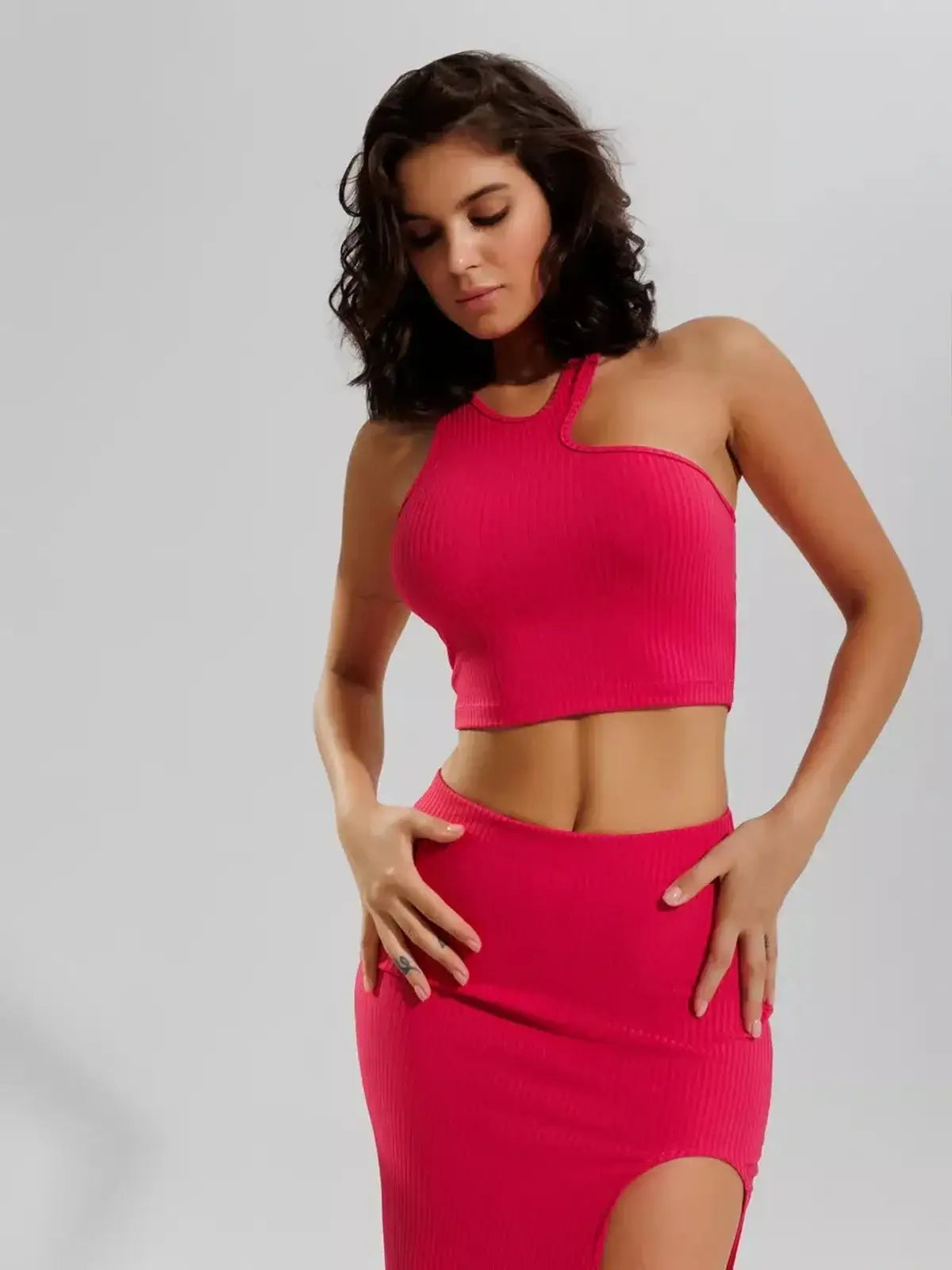 Model wearing Fuchsia Flair Set by Lauven, featuring a ribbed knit crop top and high-waisted midi skirt with thigh slit.