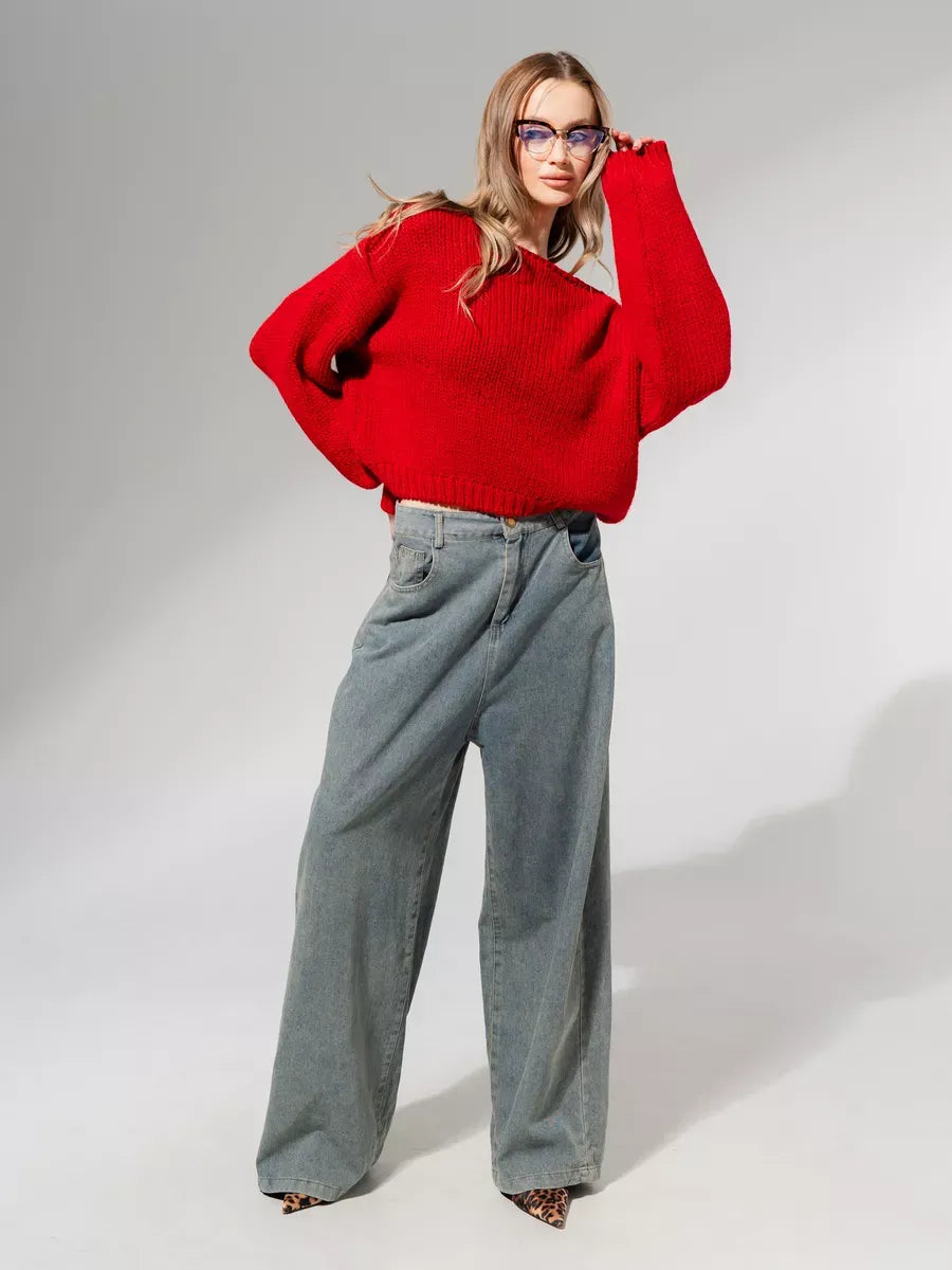 Model wearing Lauven Scarlet Sweater, an oversized off-shoulder knit in deep red paired with relaxed-fit jeans.