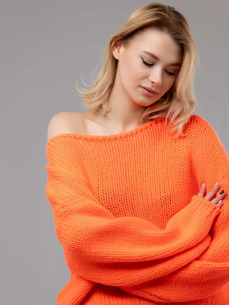 Nova Sweater by Lauven in oversized off-shoulder neon orange knit worn by a model.