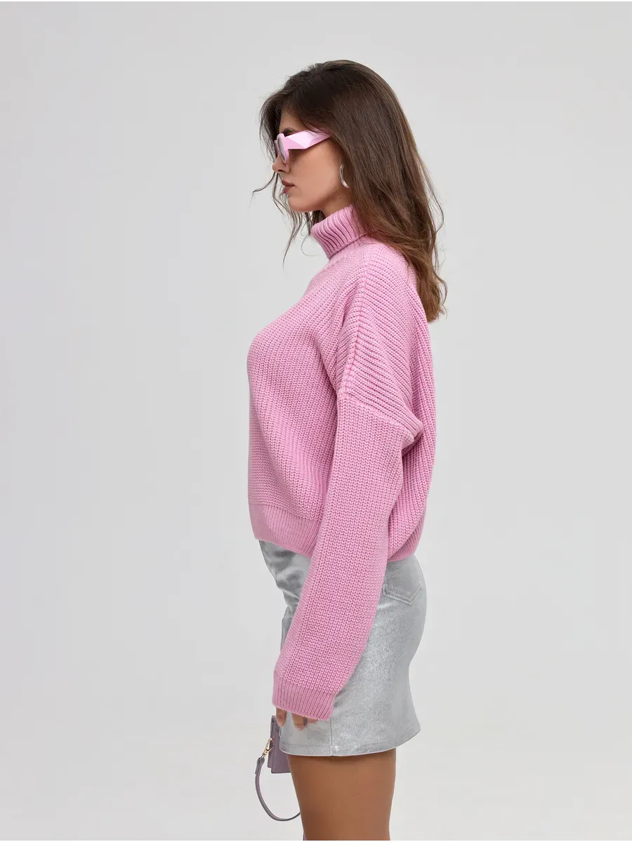 Iris Sweater by Lauven in pink, featuring oversized knit design and turtleneck worn with a silver skirt.
