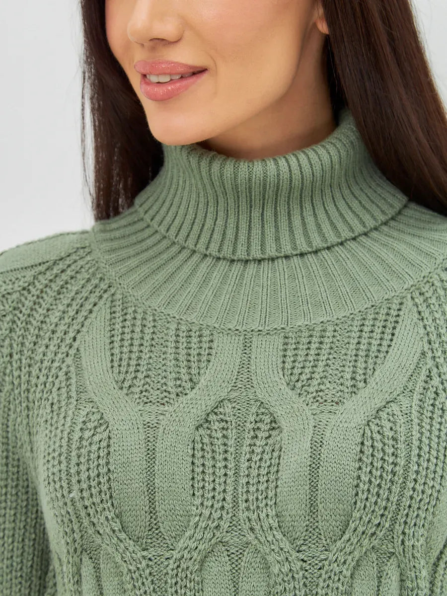 Close-up of a model wearing the Ivy Sweater by Lauven, featuring an oversized cable knit design and high neck.