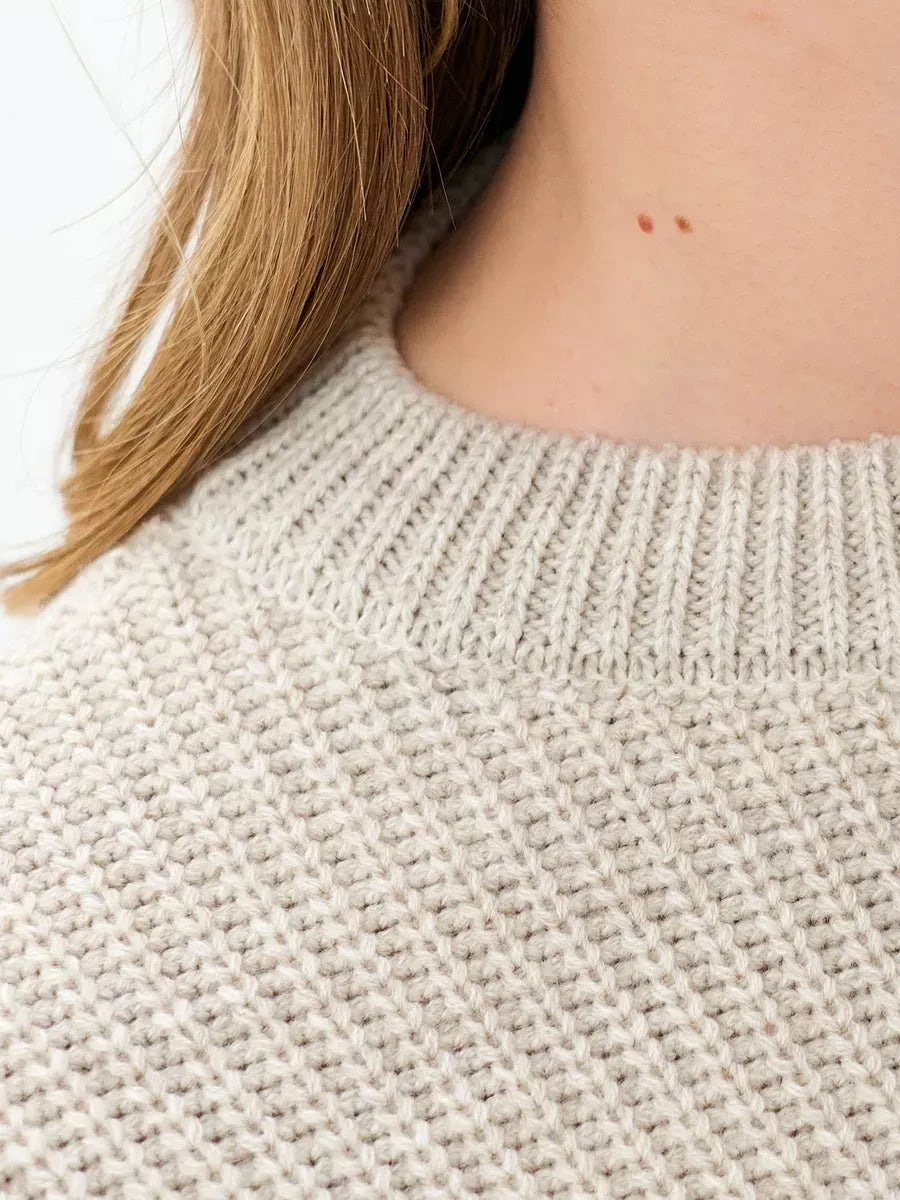 Astra Sweater close-up showing light beige knit texture and round neckline by Lauven.