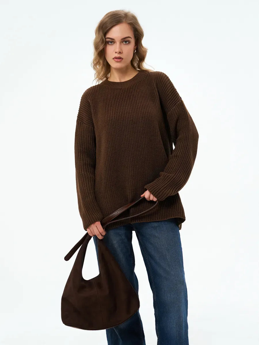 Model wearing the Atlas Sweater by Lauven, an oversized knit in rich brown, paired with a stylish handbag.