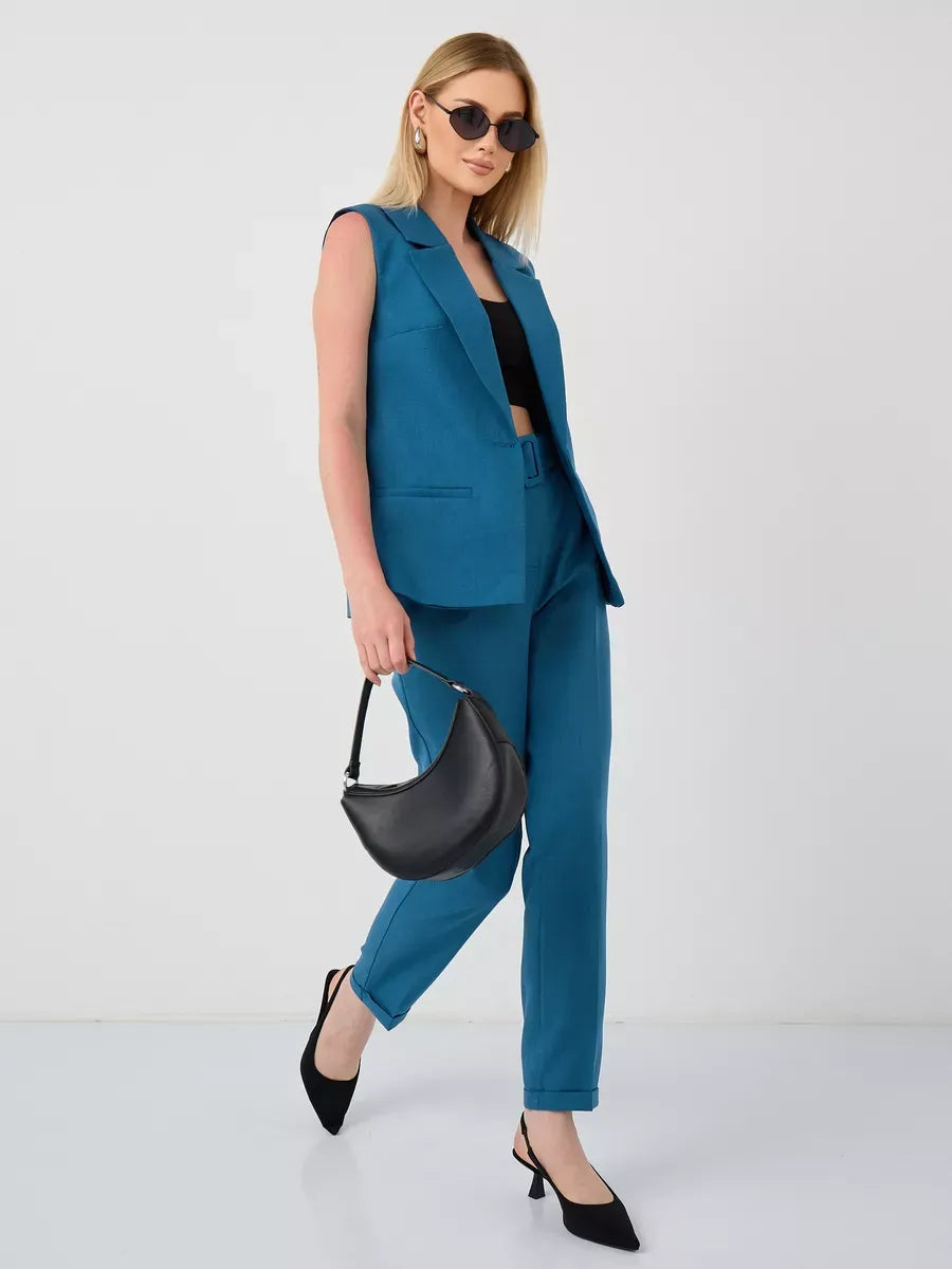 Model wearing Lauven Marine Suit Set, a sleeveless teal vest and high-waist pants, styled with black accessories.