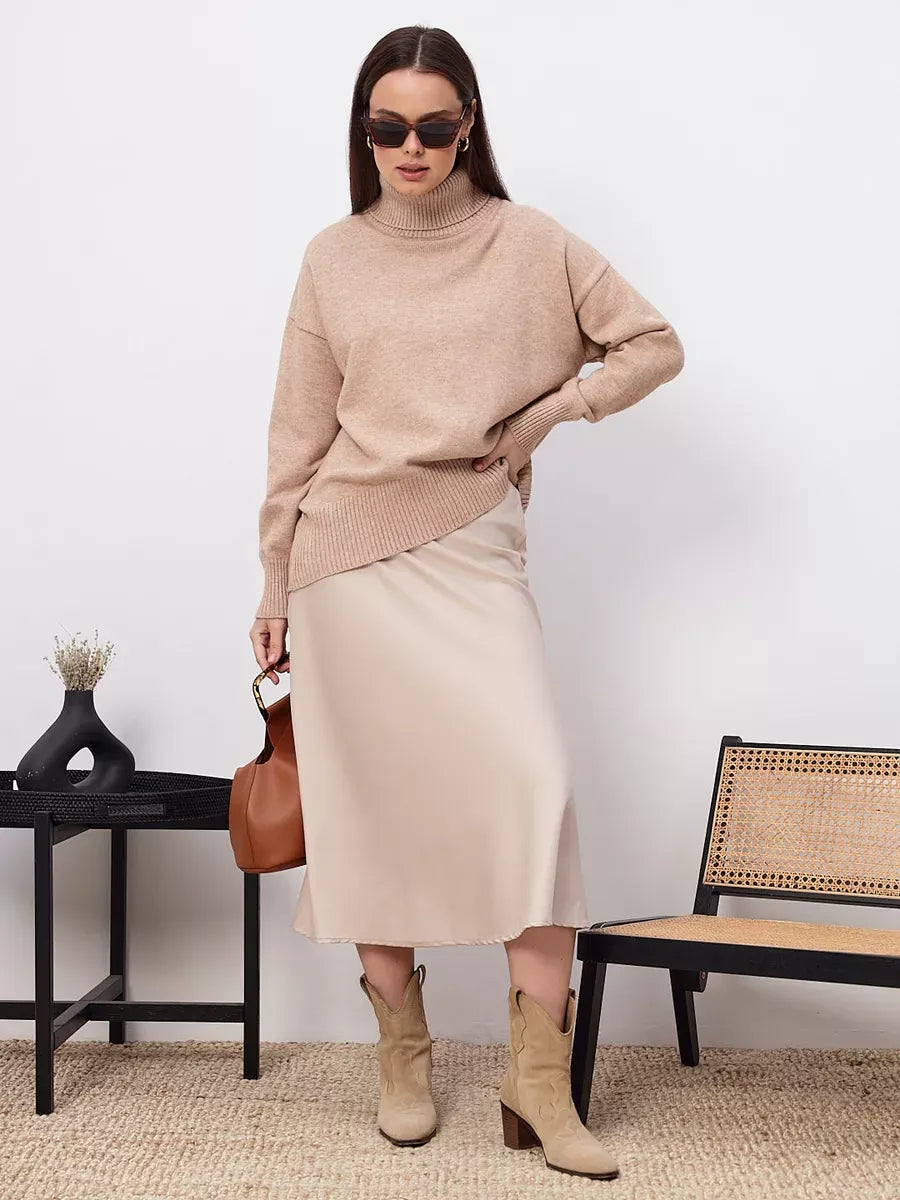 Selene Sweater by Lauven styled with a beige skirt, showcasing modern elegance and comfort in a cozy turtleneck design.