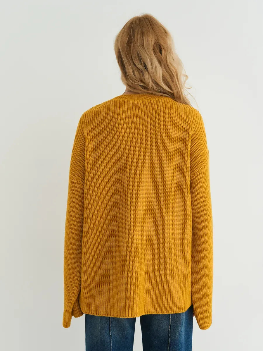 Back view of the Solara Sweater by Lauven, showcasing its oversized knit design in vibrant mustard yellow.