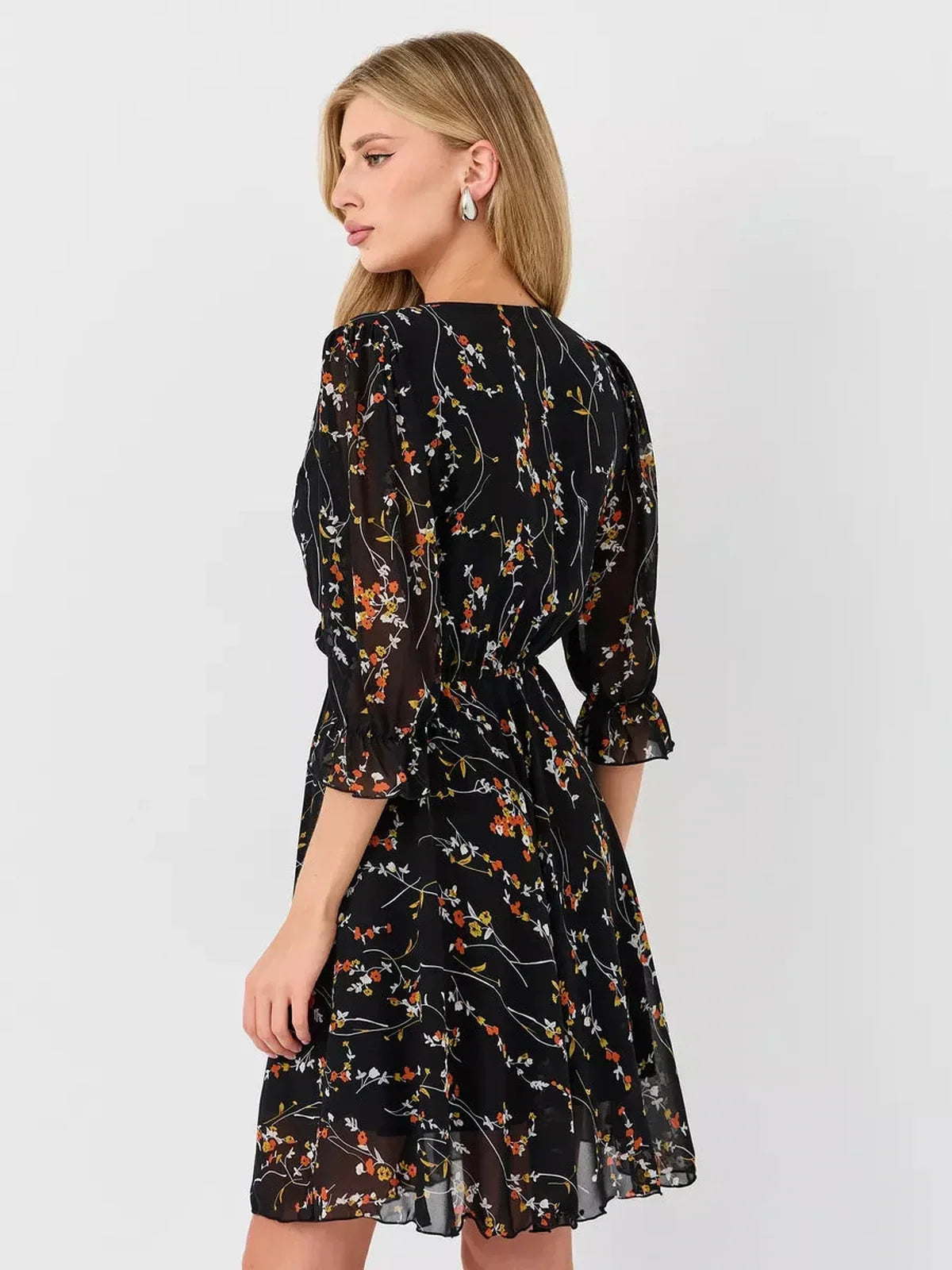 Lotus Mini Dress by Lauven, a black floral wrap dress with a deep V-neckline and 3/4 puff sleeves.