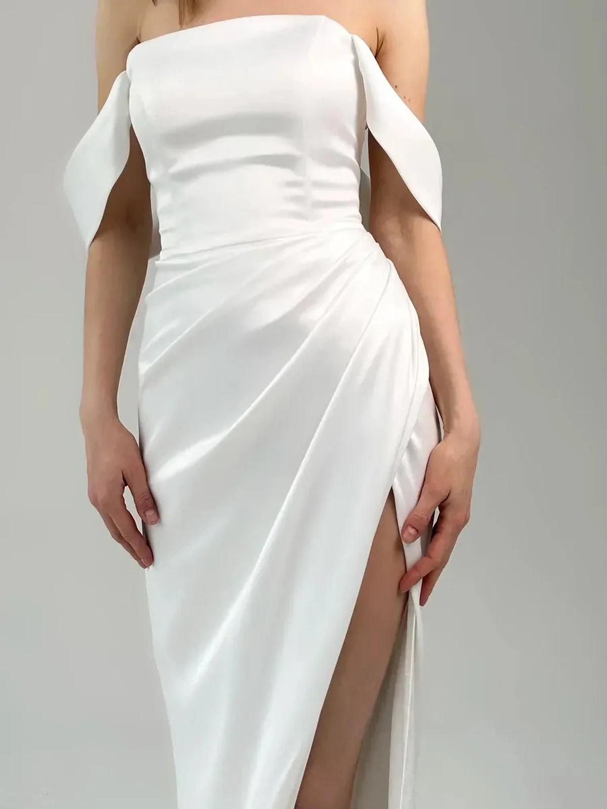 Lyra Occasion Dress by Lauven – Elegant off-shoulder white satin gown with draping and thigh-high slit.