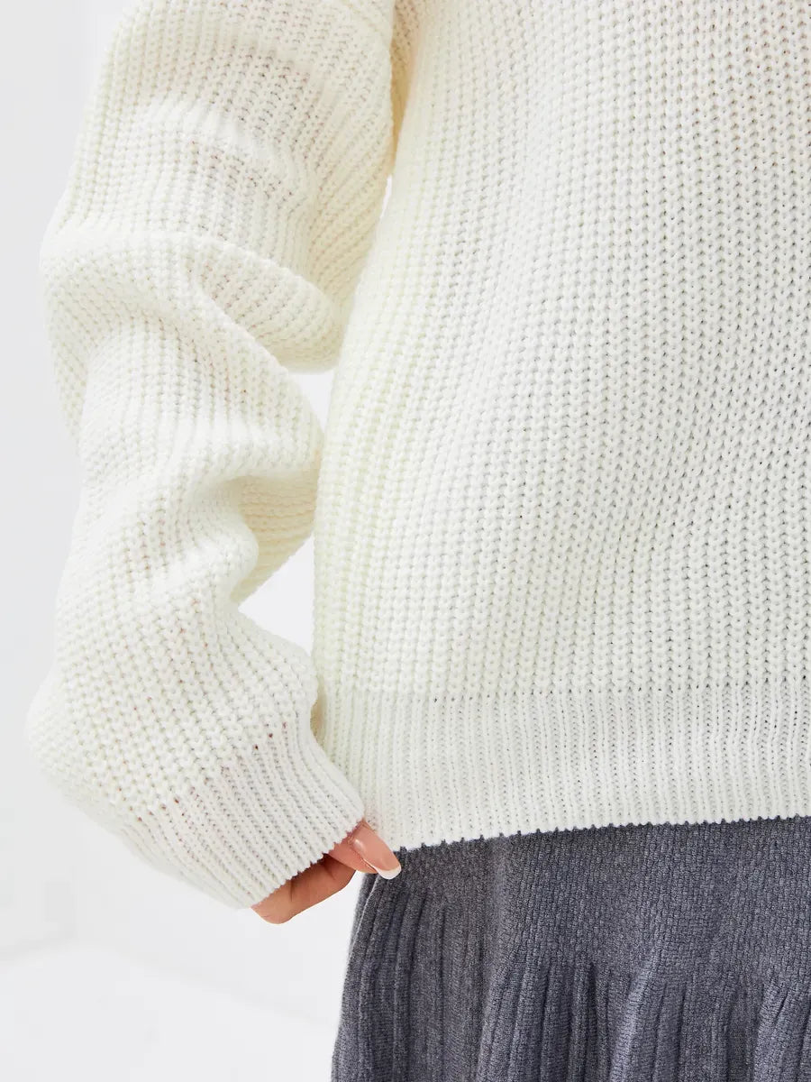 Close-up of Lyra Sweater by Lauven, an oversized knit in soft ivory with a high-neck design and textured fabric.