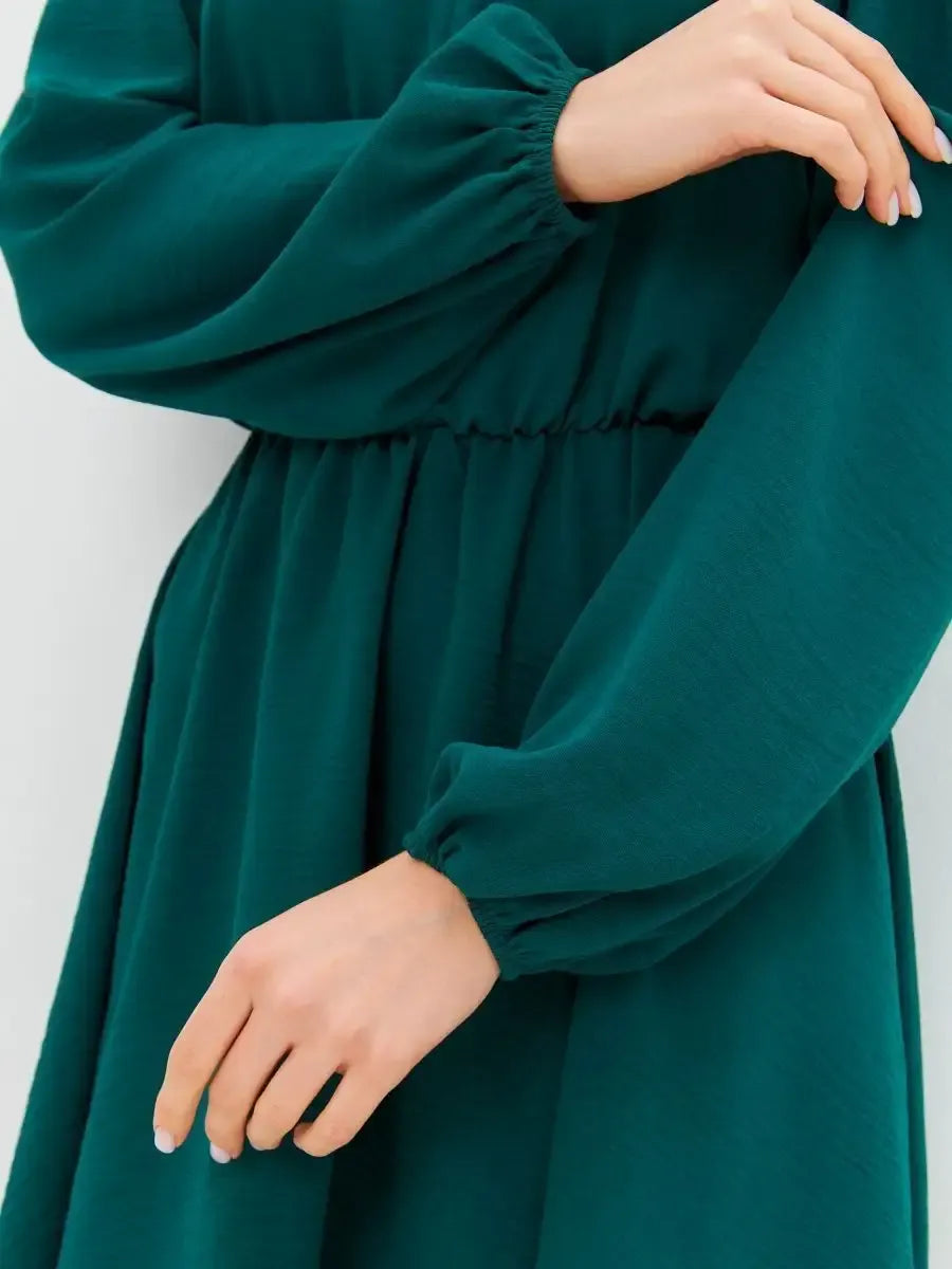 Model wearing the elegant Malachite Mini Dress by Lauven, showcasing the off-shoulder style and long sleeves.
