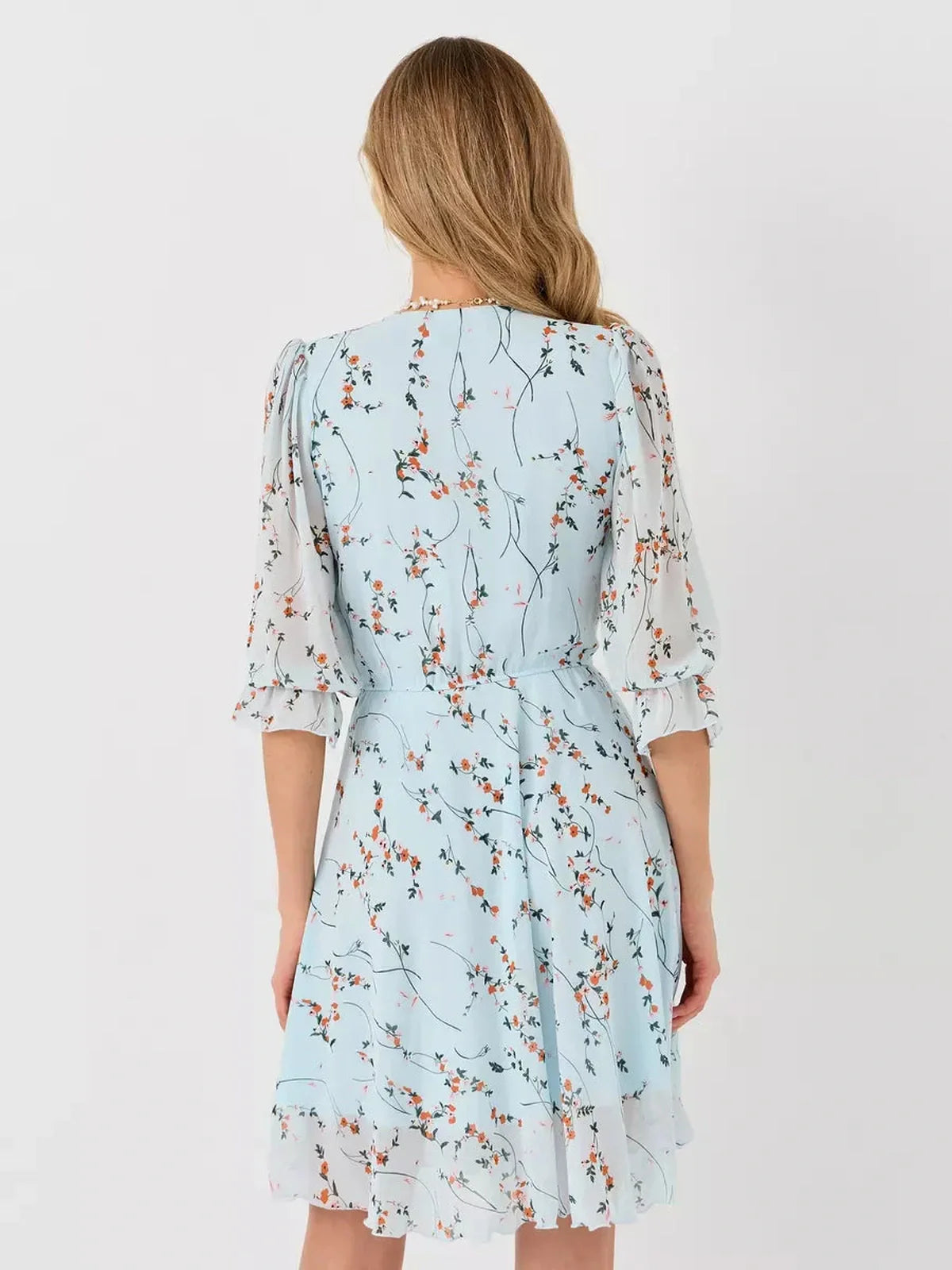 Back view of the Lauven Mara Mini Dress featuring a light blue floral design and three-quarter sleeves.