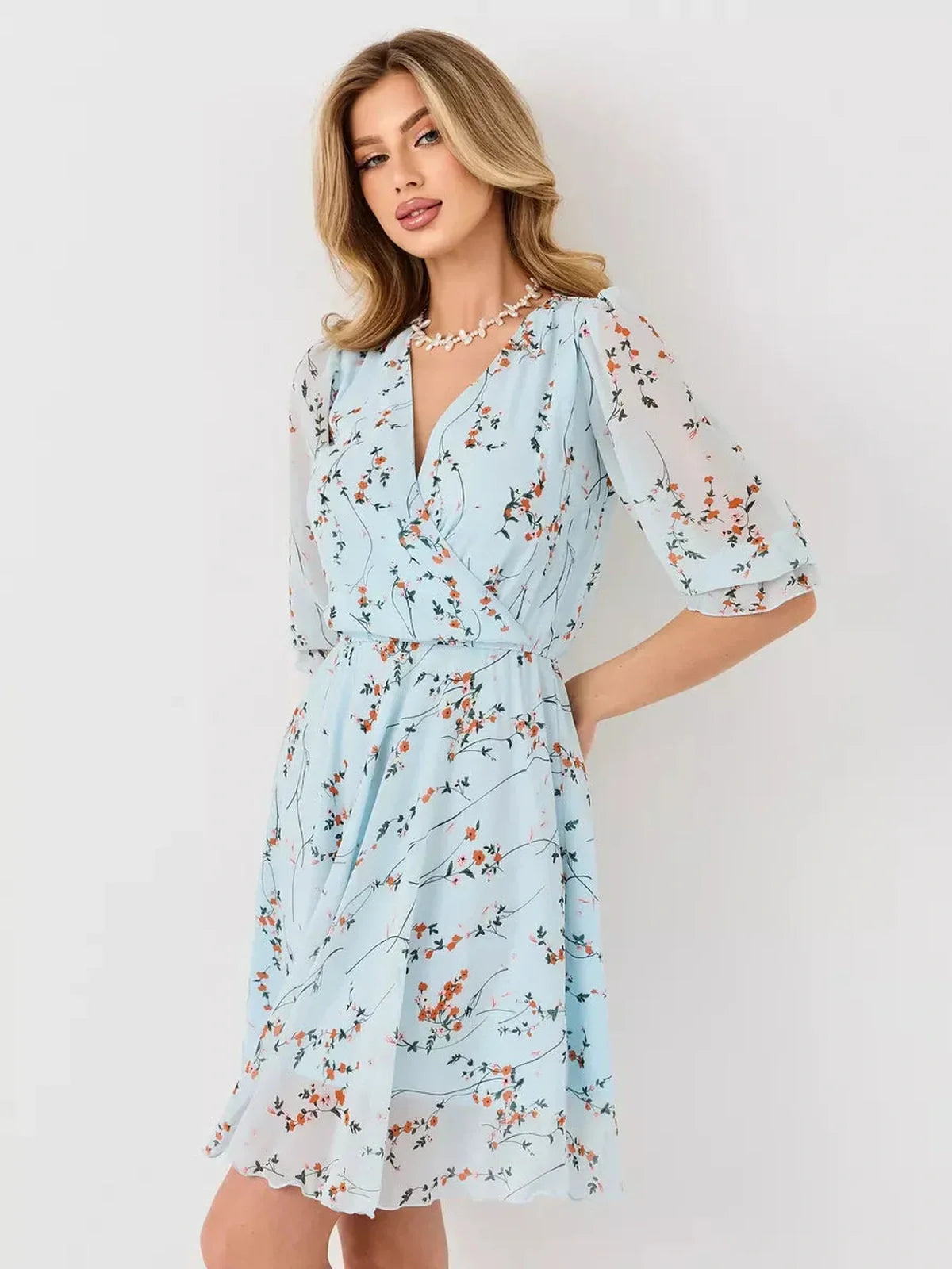 Mara Mini Dress by Lauven - Light blue floral wrap dress with V-neckline and 3/4 sleeves.