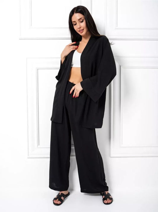 Model wearing the Noir Suit Set by Lauven, showcasing a chic oversized black two-piece set with wide-leg trousers.