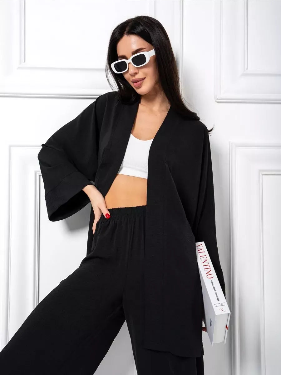 Chic model showcasing the Noir Suit Set by Lauven, an oversized black two-piece set with wide-leg trousers.