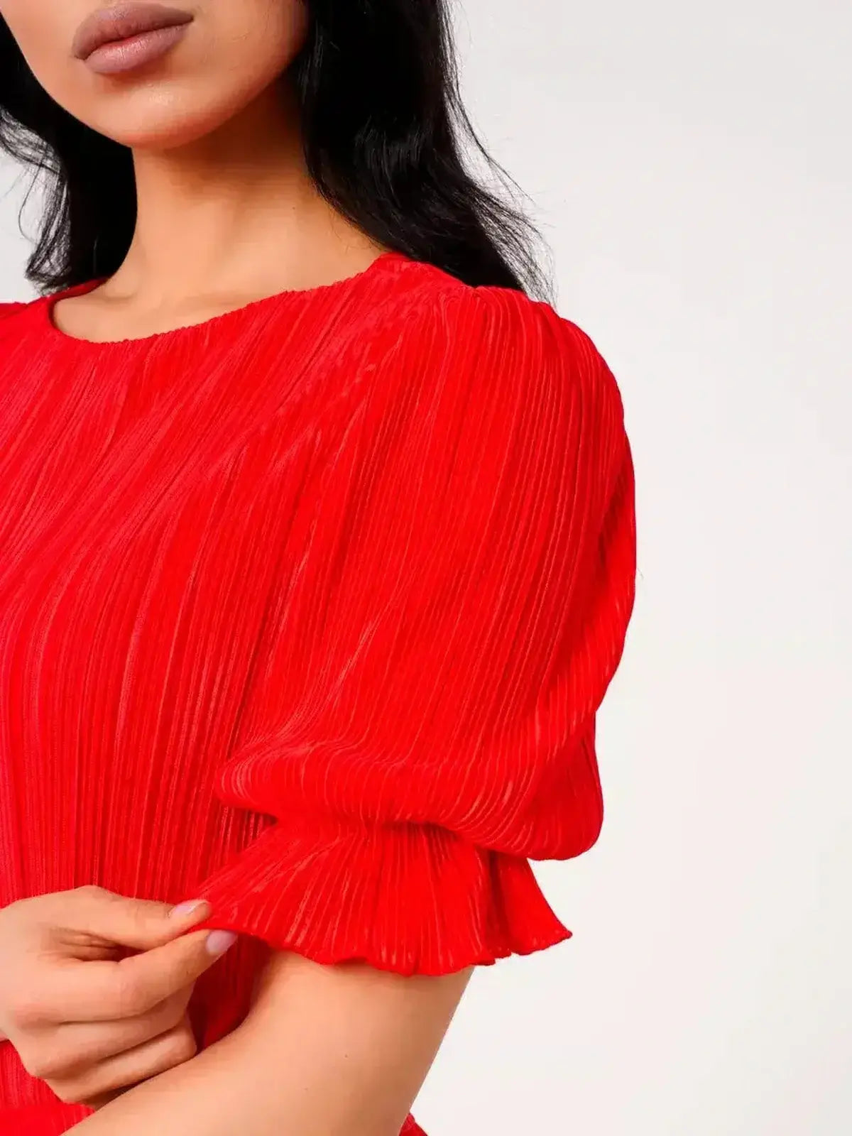 Close-up of a model's hand on the puff sleeve of the vibrant red Ophelia Maxi Dress by Lauven, showcasing pleated elegance.