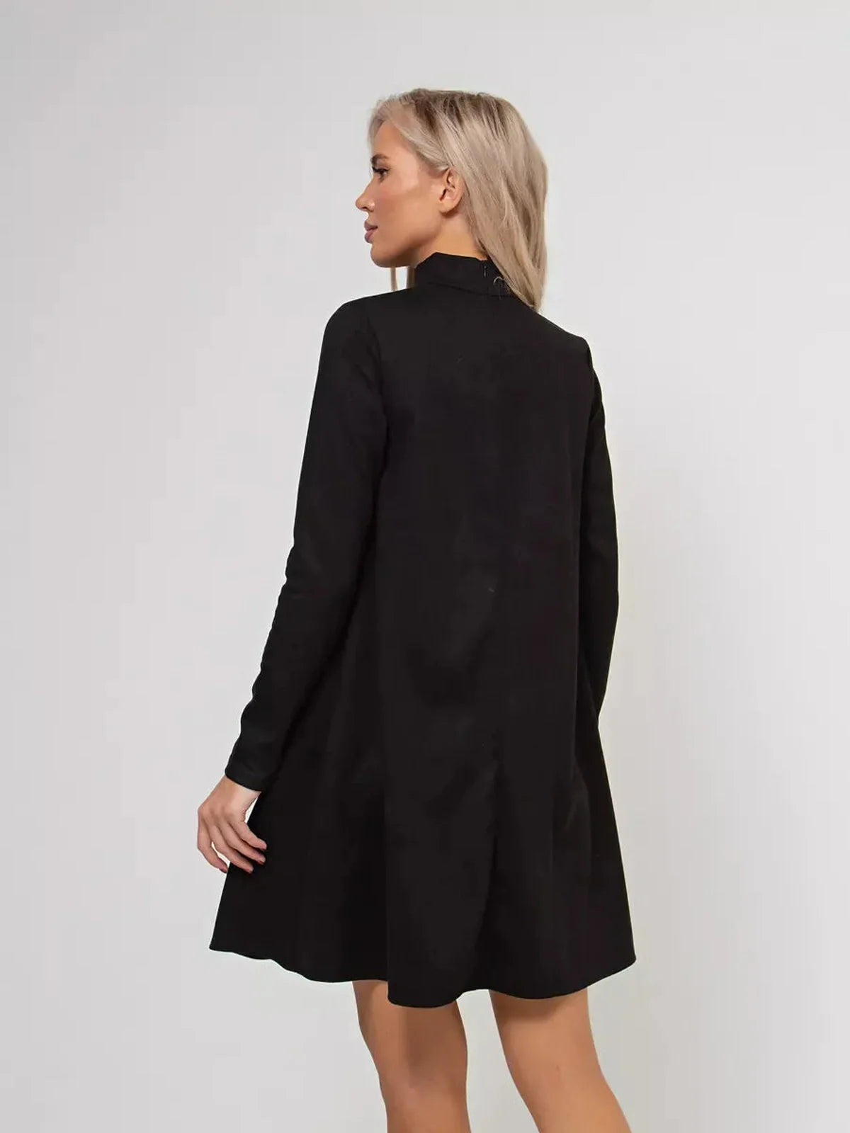 Quinn Mini Dress by Lauven shows a model from the back, featuring a black long sleeve A-line design with a mock neck.