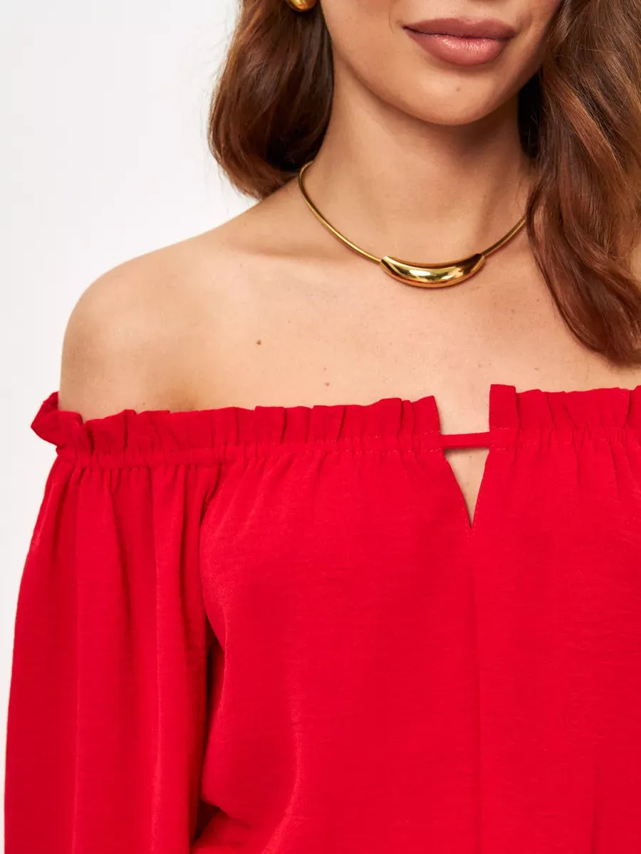 Close-up of model wearing a Scarlet Mini Dress by Lauven, showcasing off-shoulder design and elegant neckline.