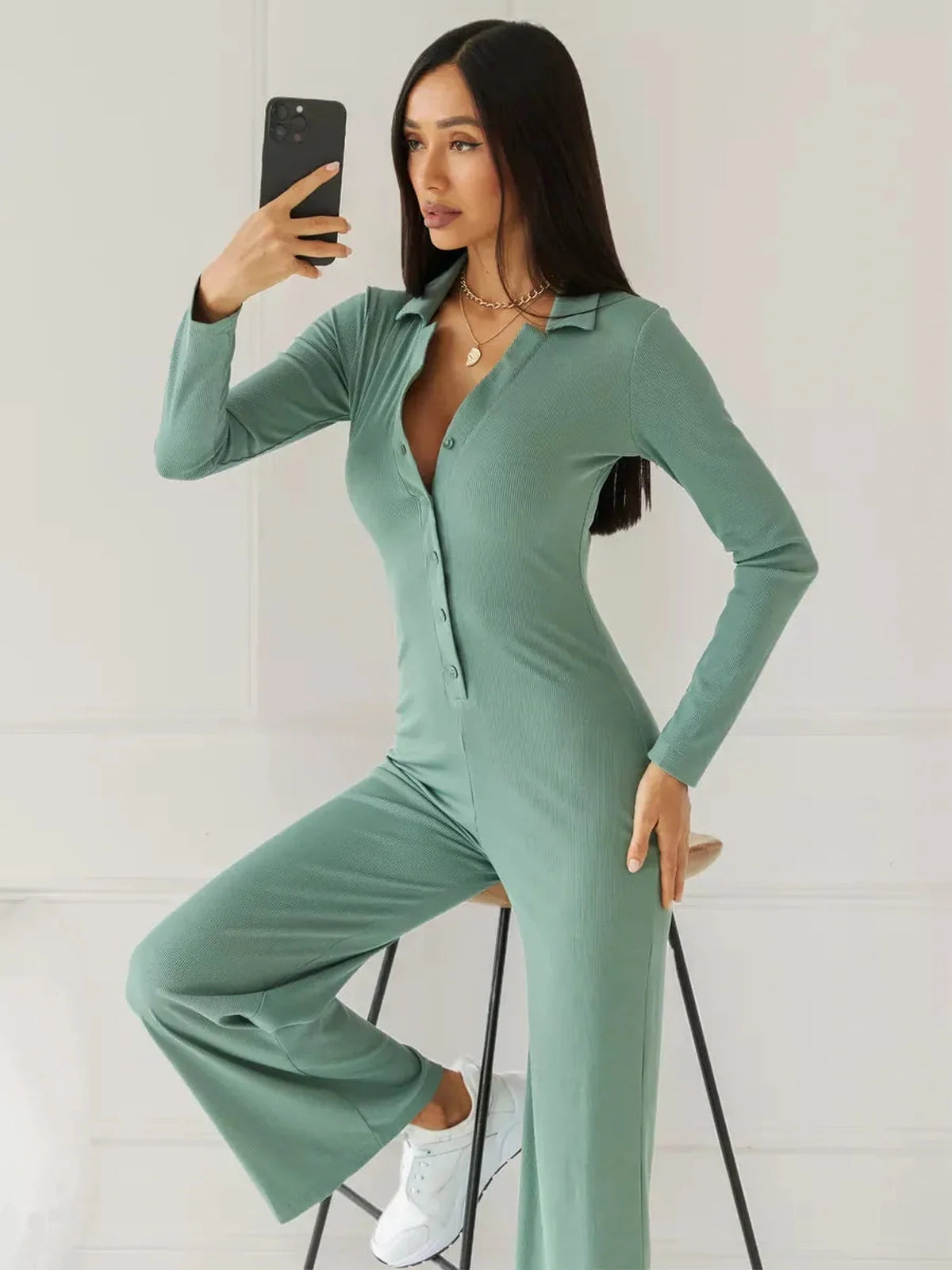 Scarlett Jumpsuit – Model in a sage green ribbed wide-leg jumpsuit, featuring a structured collar and button-down front.