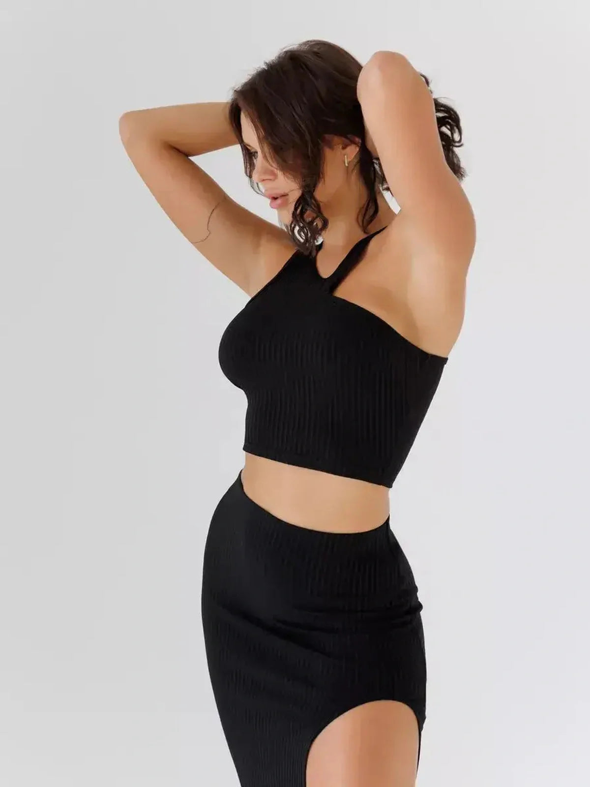 Sculpted Edge Set by Lauven featuring a stylish one-shoulder crop top and high-waisted midi skirt in ribbed black fabric.