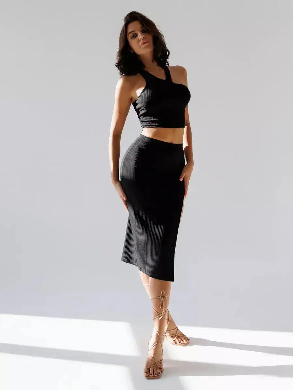 Sculpted Edge Set by Lauven, black ribbed knit two-piece with one-shoulder crop top and high-waisted midi skirt.