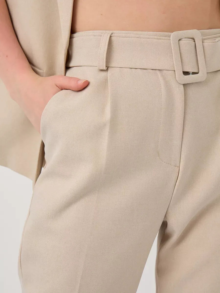 Close-up of the high-waist pants from the Solara Suit Set by Lauven, showcasing a stylish beige fabric and belt.