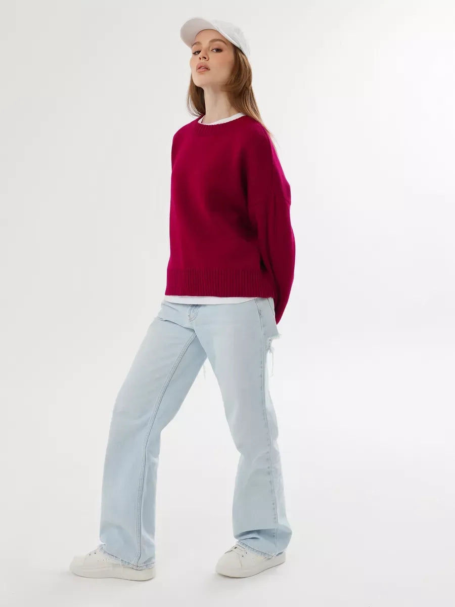 Model wearing Vela Pullover in burgundy with light denim and sneakers, showcasing Lauven brand style.
