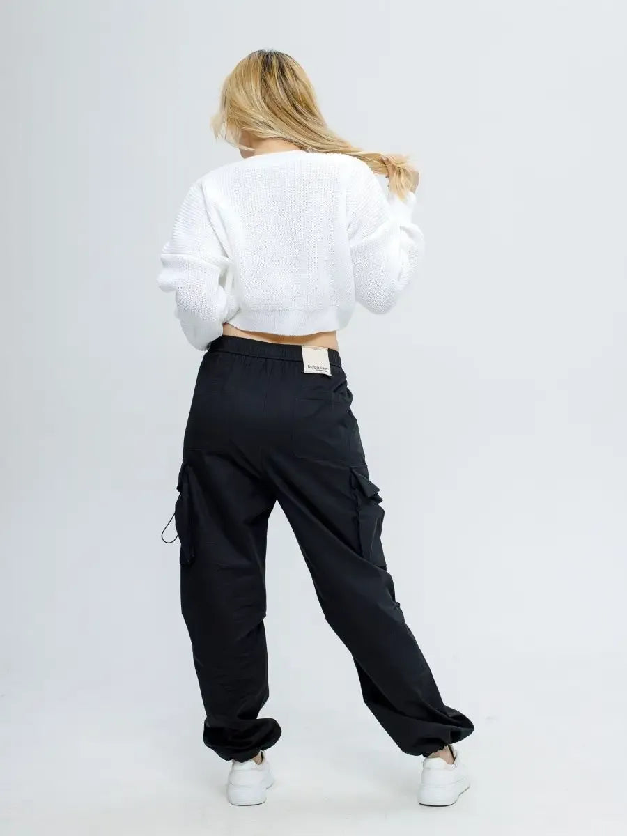 Model wearing Alba Pullover in soft white and black cargo pants, showcasing a stylish spring outfit by Lauven.