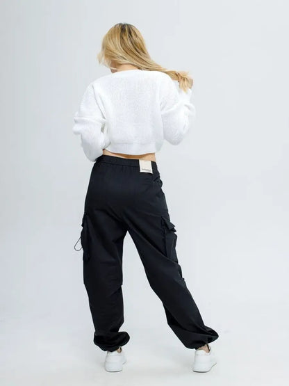 Model wearing Alba Pullover in soft white and black cargo pants, showcasing a stylish spring outfit by Lauven.