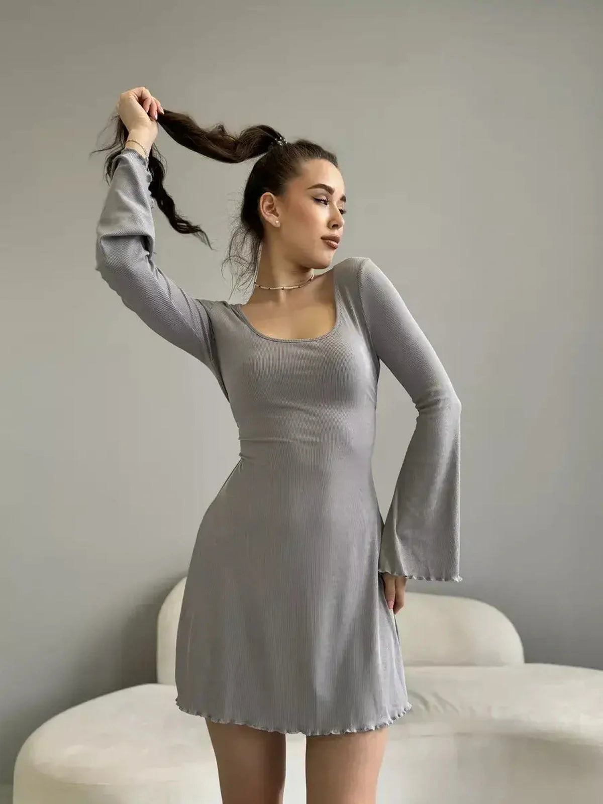 Amelia Mini Dress by Lauven, showcasing a gray ribbed knit design with bell sleeves and a tie-back detail.