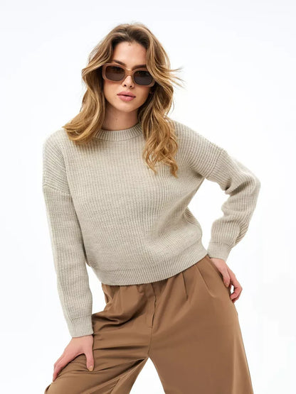 A woman wearing the Lauven Astra Sweater in light beige, embodying elegance and comfort with stylish sunglasses.