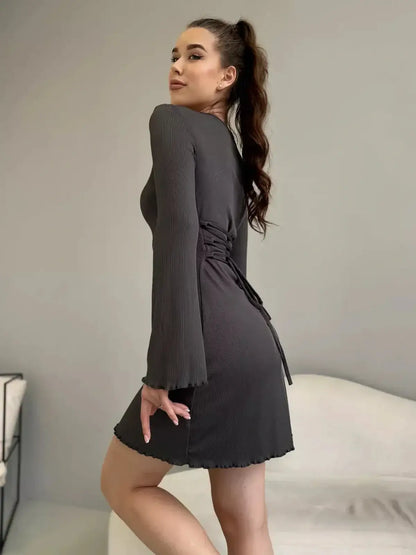 Ava Mini Dress by Lauven, featuring a ribbed knit design, long bell sleeves, and a back tie in a chic setting.