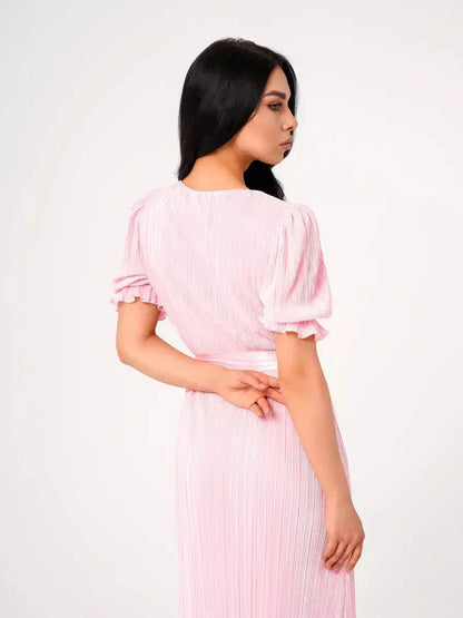 Candy Maxi Dress - Back view showcasing pleated elegance, puff sleeves, and a tie waist in soft pink fabric.