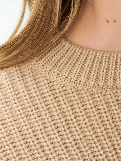 Close-up of the textured fabric of the Lauven Cappuccino Sweater in warm beige, showcasing its cozy knit design.
