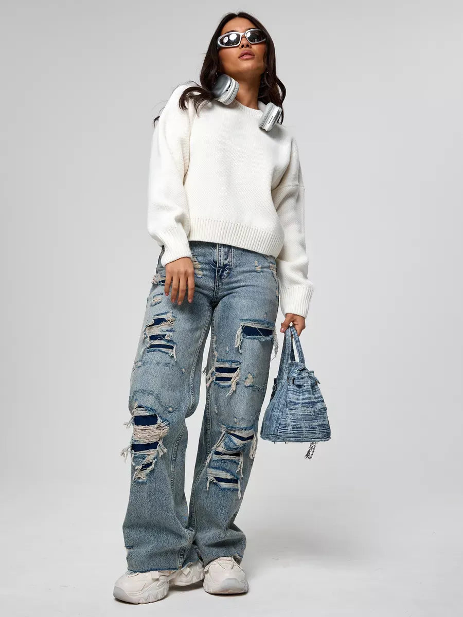Celeste Pullover by Lauven worn with ripped jeans and accessories, showcasing modern fashion style.