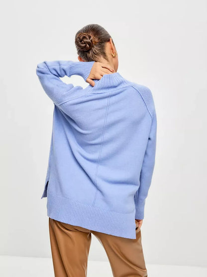 Model wearing Celeste Sweater in soft blue, showcasing the oversized design and high ribbed neckline by Lauven.