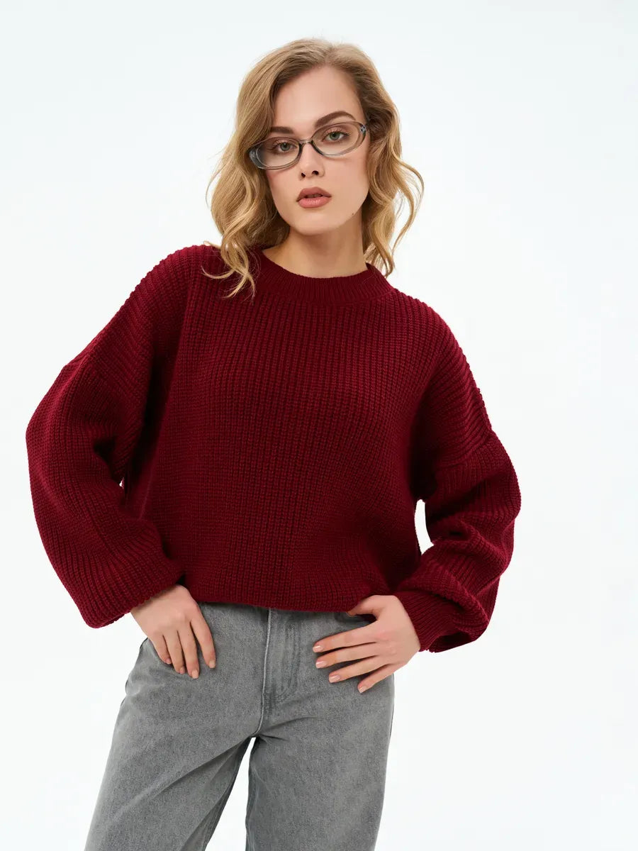 Model wearing the Crimson Charm Sweater by Lauven, an oversized knit in deep burgundy.