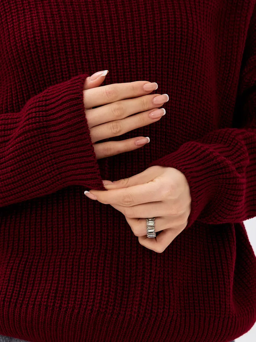Crimson Pullover by Lauven, showcasing a close-up of cozy oversized burgundy knit sweater sleeve and hands.