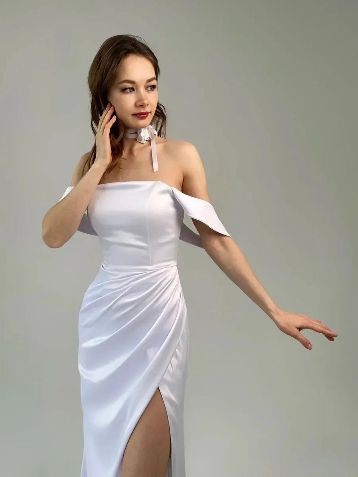 Eira Occasion Dress by Lauven – White satin off-shoulder gown with draping and high leg slit.