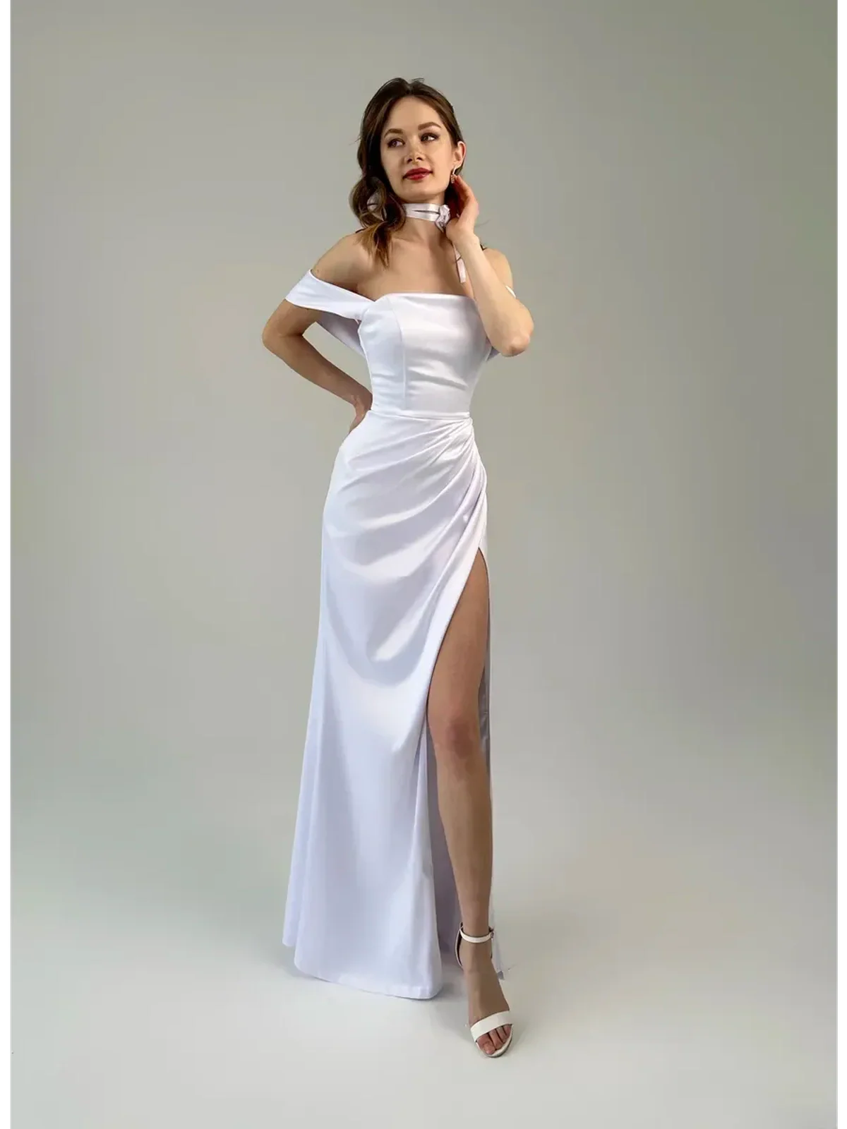 Eira Occasion Dress by Lauven - Elegant white satin off-shoulder gown with draping and high leg slit.