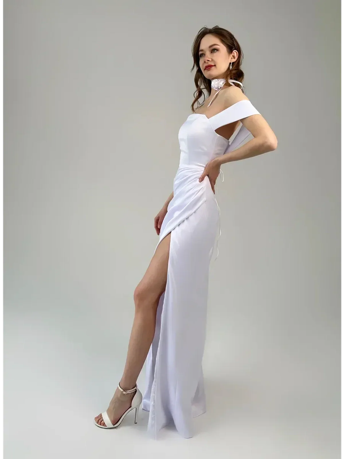 Eira Occasion Dress by Lauven – Elegant white satin off-shoulder gown with draping and high leg slit.