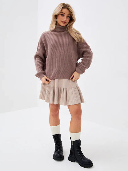 Woman wearing a cozy oversized Florence Sweater by Lauven, styled with a pleated skirt and combat boots.