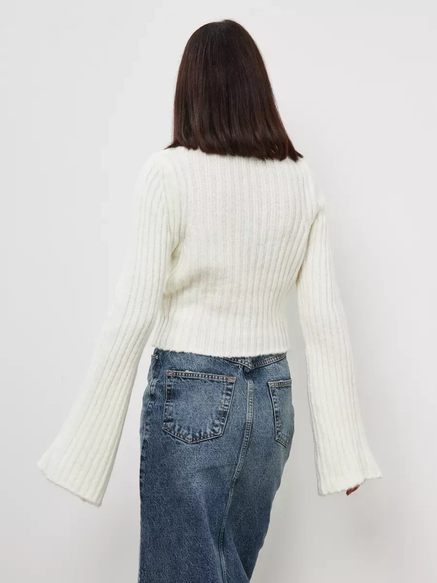 Back view of a woman in a cropped cream knit Lyra Sweater with wide sleeves from Lauven.