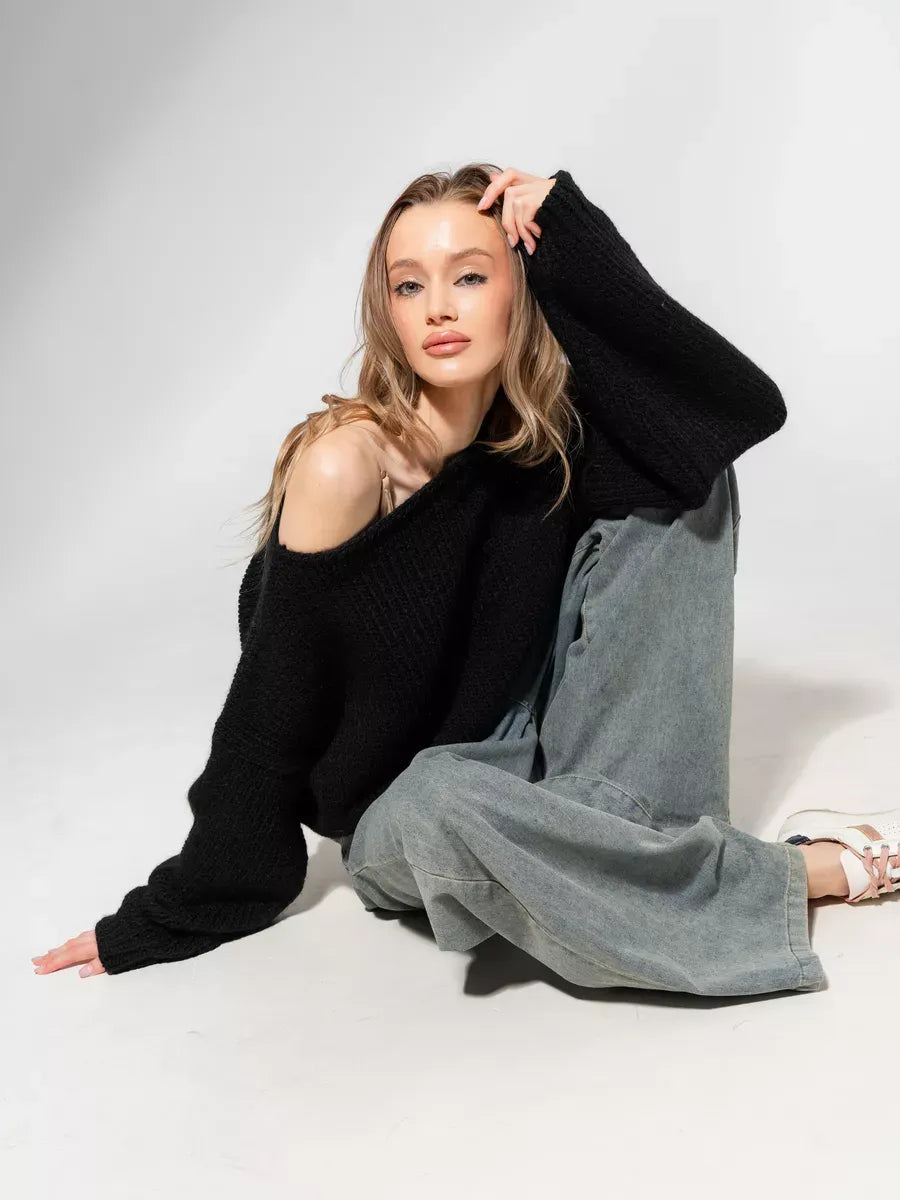 Model wearing Noir Sweater by Lauven, an oversized off-shoulder knit in classic black, embodying modern minimalism.