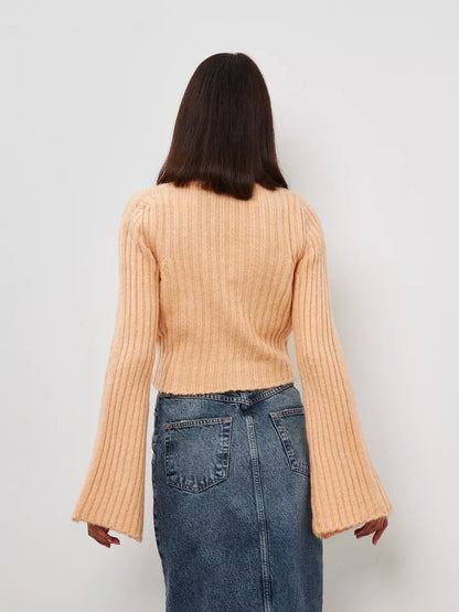 Back view of the Aurelia Sweater by Lauven featuring wide sleeves and ribbed knit texture in a soft powder hue.