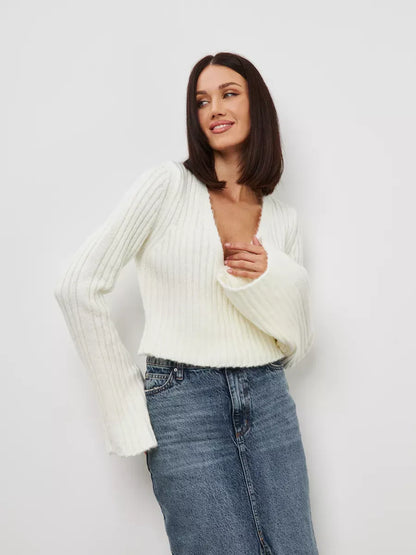 Model showcasing the Lyra Sweater by Lauven in cropped cream knit with V-neck and wide sleeves.
